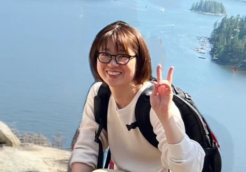 バンクーバーの入り江を背にピースをするKanaさん
